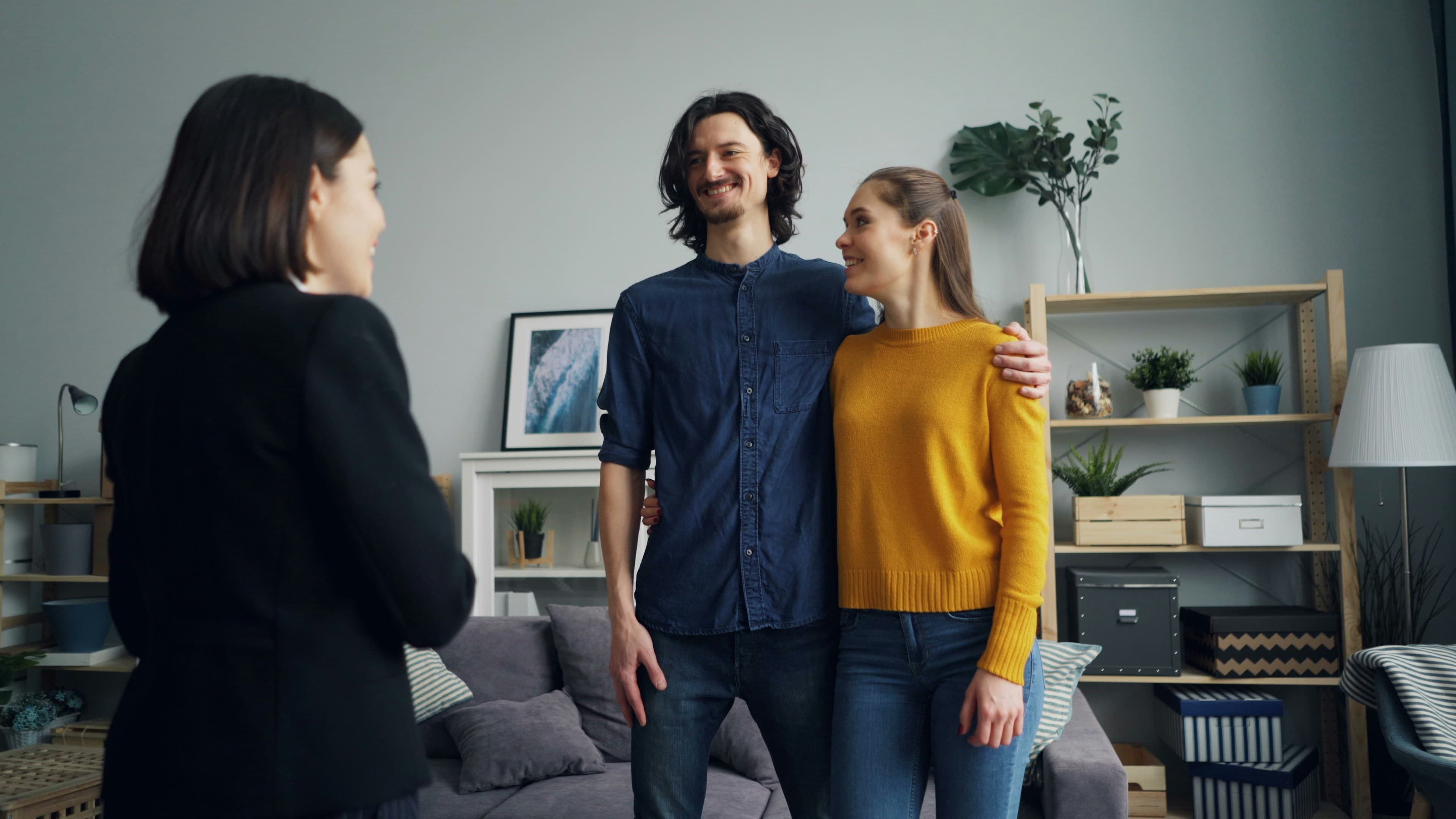 A landlord greeting tenants in a furnished rental home